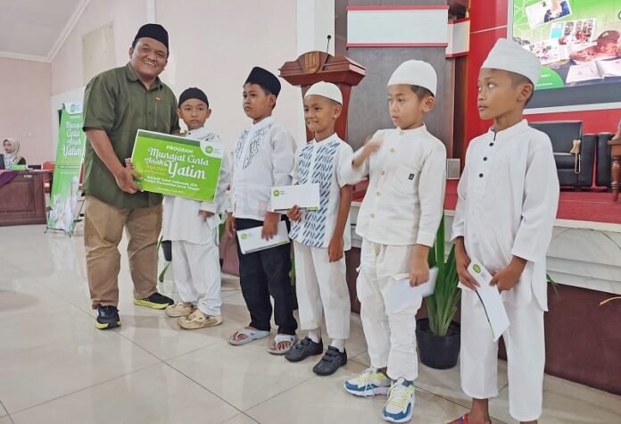 Djoko Adhi, Kepala Cabang IZI Jateng saat memberikan bantuan kepada anak yati