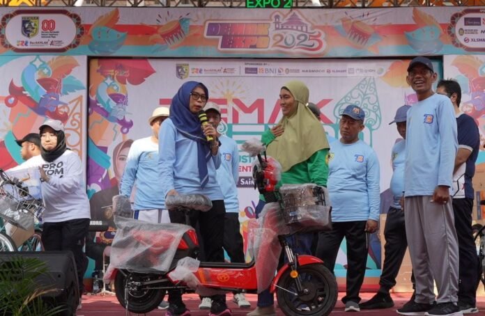 Penyerahan hadiah utama sepeda listrik kepada pemenang jalan sehat dalam rangka HUT Koperasi ke-78 di panggung Demak Expo 2025, Kamis (7/8). (Foto: Sam)