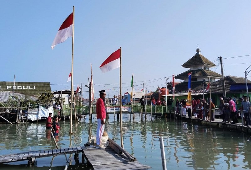 Upacara Bendera Warga Dukuh Timbulsloko, Demak, tetap khidmat menggelar upacara 17 Agustus di tengah genangan rob sebagai wujud cinta tanah air dan perjuangan mempertahankan ruang hidup