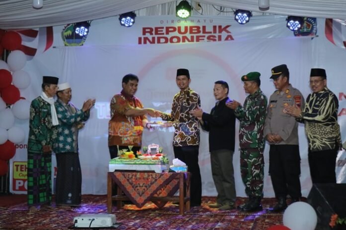 Wabup Tegal menyerahkan potongan nasi tumpeng kepada Kades Tembok Luwung