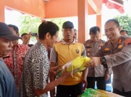 Kapolres Tegalkota AKBP I Putu Bagus Krisna Purnama (kanan) menyerahkan beras ke warga.