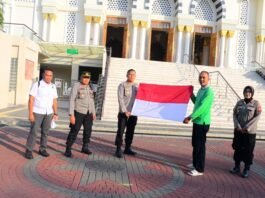 Kapolres Karanganyar AKBP Hadi Kristanto membagikan bendera merah putih kepada masyarakat di halaman Masjid Agung Madaniyah