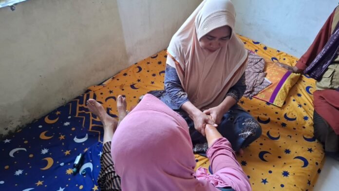 Seorang penyehat tradisional di Demak tengah memberikan pelayanan pijat. (Foto : Sam)