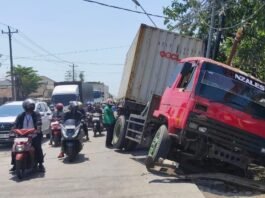 Truk tronton merah terperosok ke parit. (Foto : Sam)