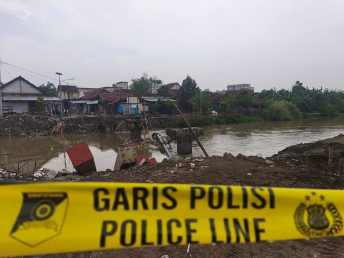 Pembangunan jembatan di Kecamatan Dempet, Kabupaten Demak, dipasangi garis polisi usai insiden maut yang menewaskan seorang pekerja tertimpa tiang pancang, Senin (20/10/2025). (Foto : Sam)