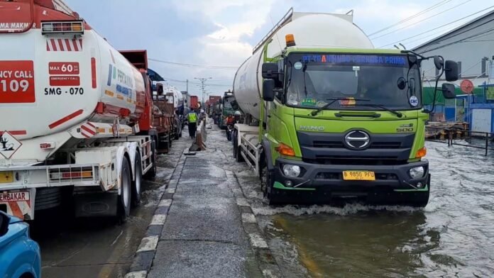 Polres Demak Polres Demak mengatur arus lalu lintas di jalur Pantura yang masih tergenang banjir di kawasan Sayung, Jumat (24/10/2025). (Foto : Sam)