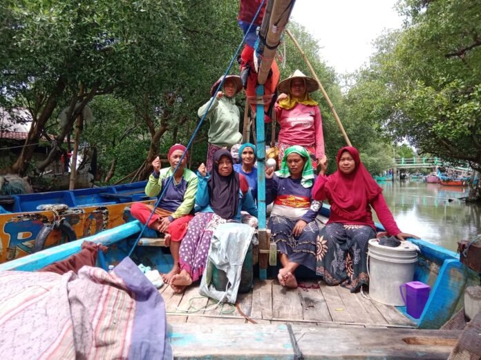 Puspita Bahari Demak berpose di atas perahu di kawasan pesisir Desa Purworejo, Kecamatan Bonang, Kabupaten Demak. (Foto : Sam)