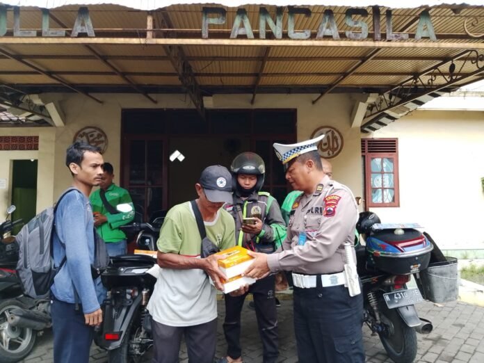 Polres Demak membagikan paket makanan kepada warga dalam kegiatan Jum’at Berkah sekaligus menyosialisasikan tertib lalu lintas menjelang Operasi Zebra Candi 2025. (Foto:Sam)