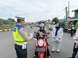 Brosur keselamatan berlalu lintas kepada pengendara motor dalam giat edukasi di jalan raya, sebagai upaya meningkatkan kesadaran masyarakat terhadap tertib berlalu lintas, Rabu (19/11/2025). (Foto:Sam)