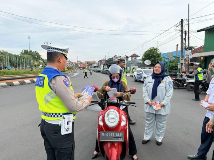 Brosur keselamatan berlalu lintas kepada pengendara motor dalam giat edukasi di jalan raya, sebagai upaya meningkatkan kesadaran masyarakat terhadap tertib berlalu lintas, Rabu (19/11/2025). (Foto:Sam)