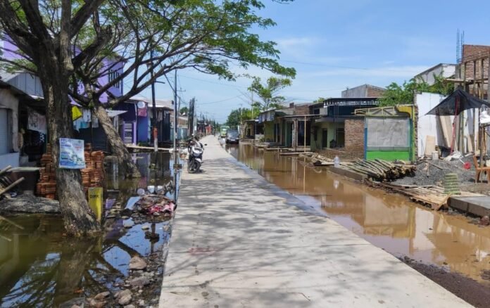 Banjir di Kalisari, Sayung, membuat warga harus berhati-hati saat melintas menggunakan sepeda dan sepeda motor, Kamis (20/11/2025). (Foto:Sam)