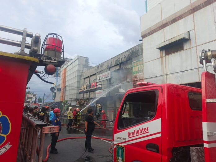 Petugas pemadam kebakaran memadamkan api yang membakar Tirtonadi Motor. (Foto : Istimewa)