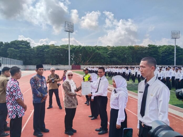 Bupati Demak Eisti’anah menyerahkan SK PPPK Paruh Waktu kepada perwakilan penerima di Stadion Sultan Fatah Sport Center, disaksikan jajaran Forkopimda dan ratusan peserta, Jumat (12/12/2025). (Foto: Sam)