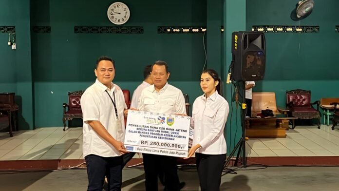 Bank Jateng bersama Pemerintah Kabupaten Kudus menyalurkan bantuan sarana usaha dan modal bagi para Pedagang Kaki Lima (PKL) di Lapangan Tenis Indoor Angga Sasana Krida, Rabu (31/12/2025). (Foto : Dok Bank Jateng)