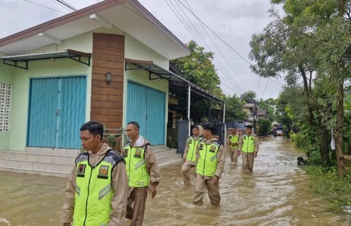 Personel Polres Kudus menyalurkan bantuan logistik menggunakan perahu kepada warga terdampak banjir di Kabupaten Kudus, Senin (12/1/2026). (Foto:Sam)