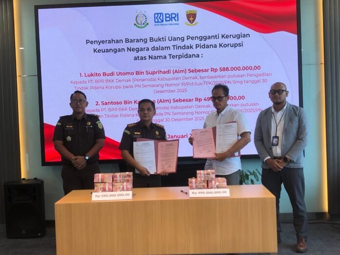Kapala Kejari Demak menyerahkan uang pengganti kerugian negara sebesar Rp1,07 miliar dalam perkara korupsi penyaluran kredit BPR BKK Demak, disaksikan jajaran BRI Cabang Demak dan pihak terkait, Senin (19/1/2026). (Foto: Sam)