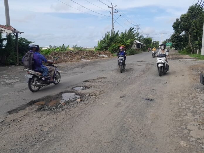 Pengguna jalan sedang melewati jalan yang berlubang serta bergelombang hal ini sangat memicu terjadinya kecelakaan, Senin (19/1/26). (Foto: Arif)