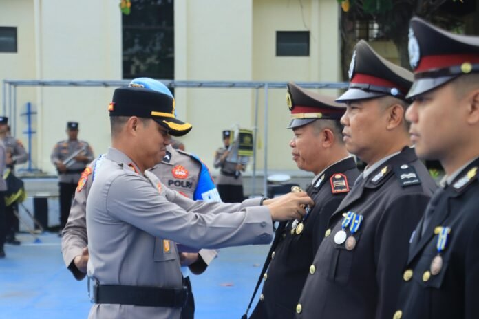 Kapolres Karanganyar AKBP Arman Sahti menyematkan tanda penghargaan kepada salah satu anggota Polres setempat. (Humas Polres Karanganyar)