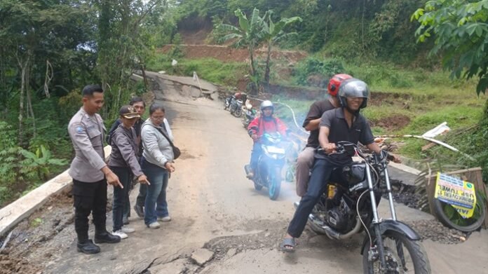 Personel polisi ketika meninjau jalan ambles di Bojong Kab Tegal