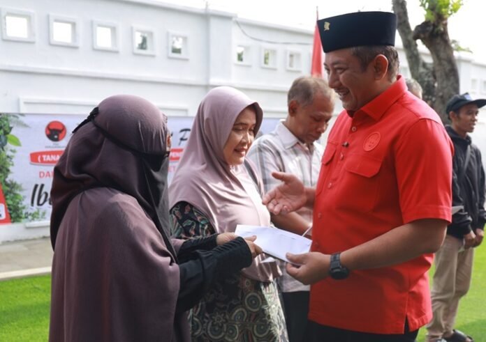Ketua DPC PDI Perjuangan Rober Christanto memberikan bantuan kepada warga dalam rangka HUT ke 79 Megawati Soekarnoputri.