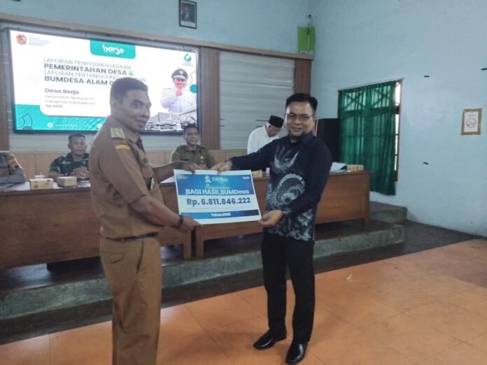 Dirut BUMDes Berjo menyerahkan secara simbolis nilai pendapatan kepada Kades Berjo, Dwi Haryanto. (Foto : Iwan)