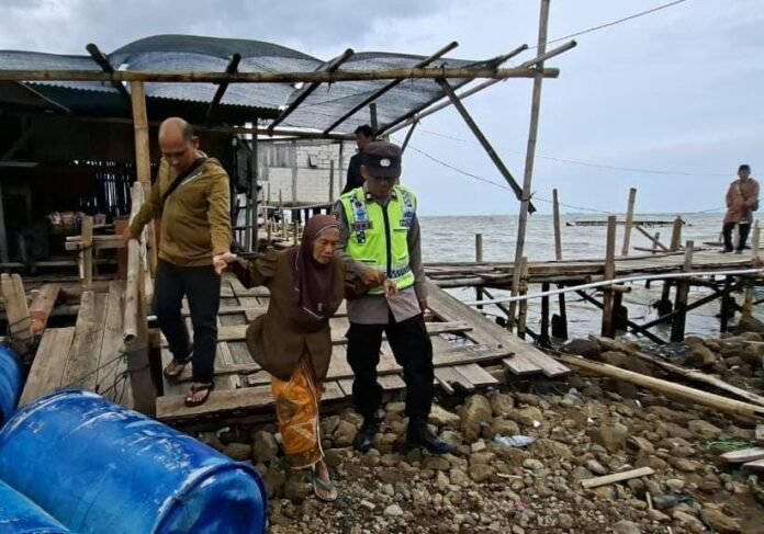 Kapolsek Sayung bersama tim Puskesmas Sayung 1 menyalurkan bantuan sosial dan layanan kesehatan kepada warga Dukuh Tambaksari, Desa Bedono, Demak, yang terisolir akibat abrasi dan gelombang pasang. (Foto:Sam)