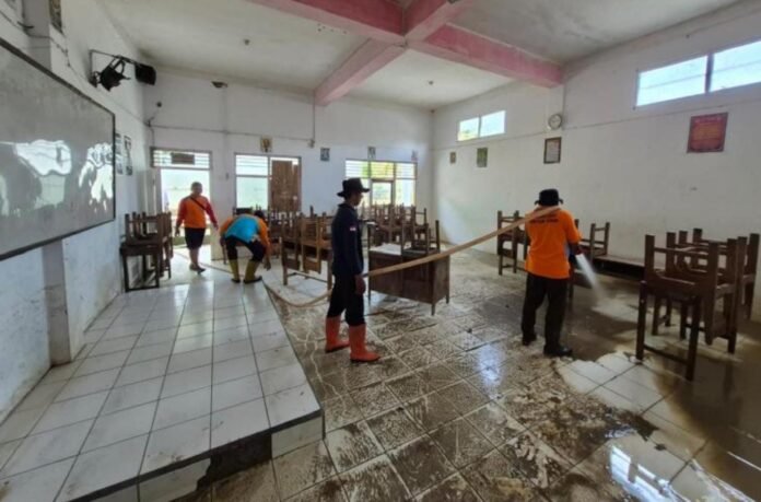 Petugas gabungan melakukan pembersihan lumpur sisa banjir di ruang kelas MTS Kebonagung, Kabupaten Demak, sebagai upaya percepatan pemulihan fasilitas pendidikan pascabanjir, Jumat (20/2/2026). (Foto:Sam)