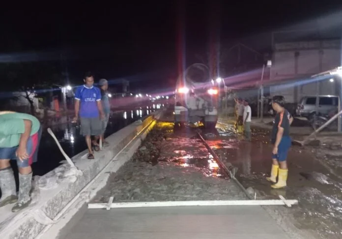Warga secara swadaya melakukan pengecoran jalan penghubung Desa Sayung–Kalisari, Kecamatan Sayung, Demak, melalui penggalangan dana kotak amal demi kelancaran akses pendidikan dan ekonomi. (Foto:Sam)