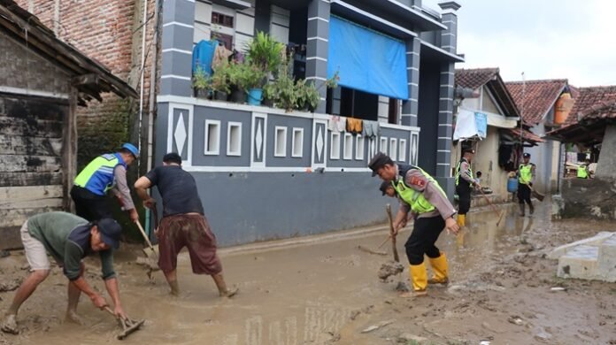 Polisi dan warga ketika kerja bakti pasca banjir