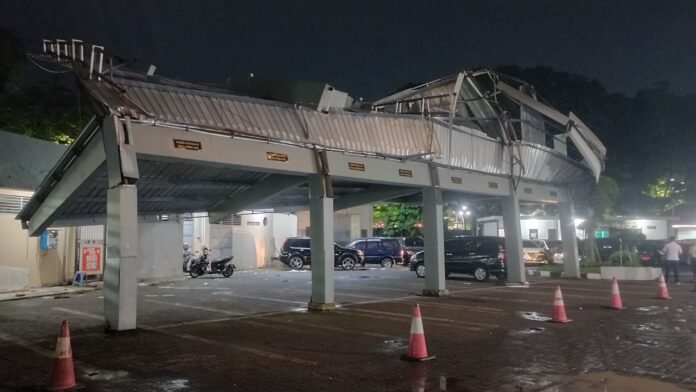 Kanopi parkiran mobil pegawai terlihat nyaris roboh setelah diterpa angin kencang, Rabu (4/3/2026). (Foto: Kamal)