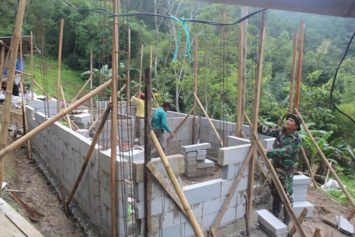 Anggota Satgas TMMD Reguler ke-127 Kodim 0709/Kebumen, Serda Heri, membantu pemasangan hebel. (Foto : Dokumen)