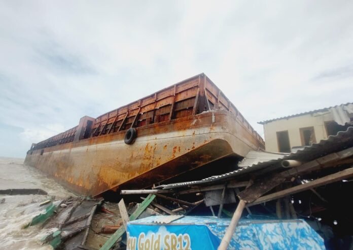 Kapal tongkang yang terlepas akibat cuaca buruk menghantam permukiman warga dan akses menuju Makam Syekh Mudzakir di Dukuh Tambaksari, Desa Bedono, Kecamatan Sayung, Demak, Sabtu (7/3/2026). (Foto:Sam)