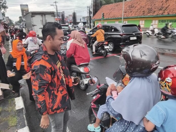 Ketua MPC PP Karanganyar Disa Ageng Alifven membagikan takjil kepada pengguna jalan.
