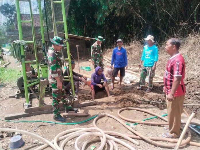 Akses air bersih bagi warga Desa Puro, Kecamatan Karangmalang, Kabupaten Sragen, Serka Sugeng tampak sigap membantu pemasangan alat bor sumur. (Foto : Dok TMMD Sragen)