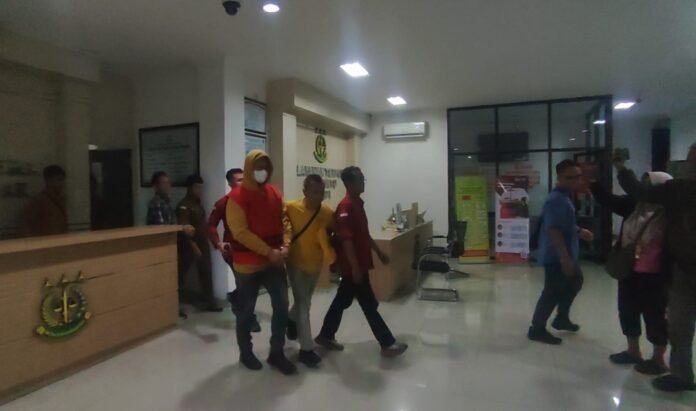 Mngenakan rompi tahanan warna kuning, tersangka AM saat dibawa menuju ruang tahanan Mapolres Karanganyar. (Foto : Iwan)