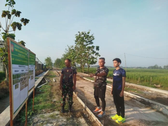 Kepala Staf Kodim 0725/Sragen Mayor Cba Beni Yusdiantoro, SE melaksanakan pengecekan sekaligus menjajal jalan cor beton hasil TMMD Reg 128. (Foto : Dok TMMD Sragen)