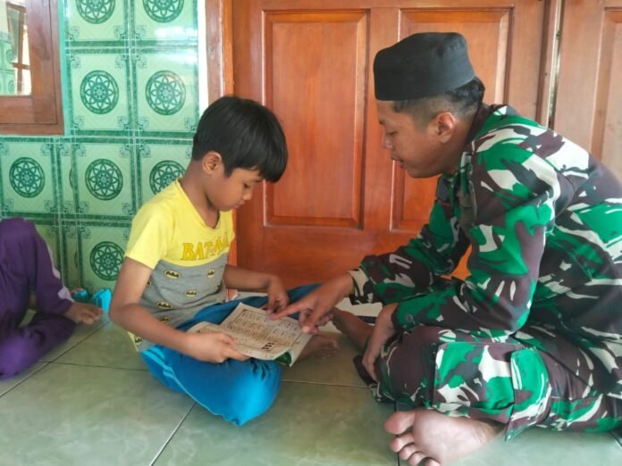 Anggota Satgas TMMD Reguler ke-128 Kodim 0725/Sragen, Praka Bazir dan Pratu Aziz saat mengajar mengaji. (Foto : Dok TMMD Sragen)