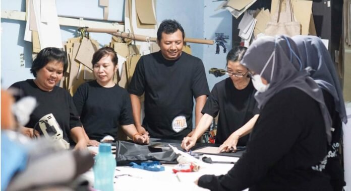 Para perajin di rumah produksi Mamnich Tas'souvenir, Solo, sedang menyelesaikan proses awal pembuatan tas etnik berbahan wastra Nusantara. UMKM binaan Bank Jateng ini berkomitmen menjaga kualitas produk home industri sekaligus menggerakkan ekonomi warga lokal. (Foto : Dok Bank Jateng)