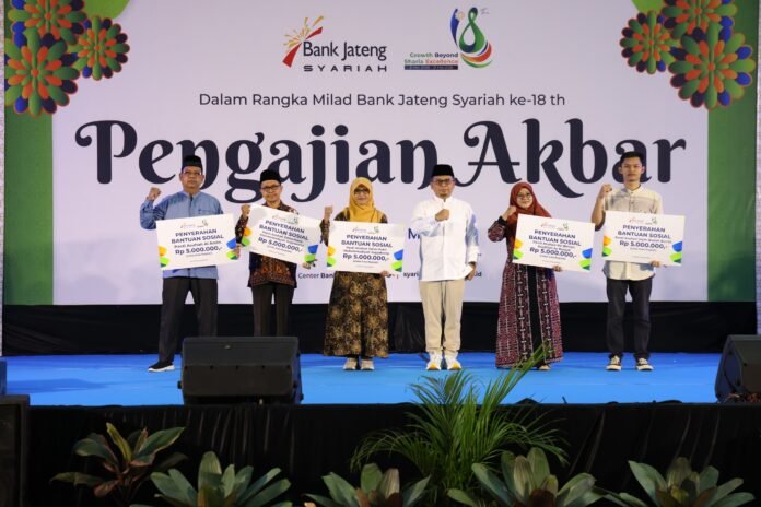Direktur Bisnis Kelembagaan dan Unit Usaha Syariah Bank Jateng, Mas Waris (tengah), menyerahkan bantuan sosial kepada sejumlah panti asuhan dalam rangka Pengajian Akbar Milad ke-18 Bank Jateng Syariah di Gedung MP Prof Amin Abdullah UIN Sunan Kalijaga, Yogyakarta, Minggu (24/5/2026). (Foto : Dok Bank Jateng)