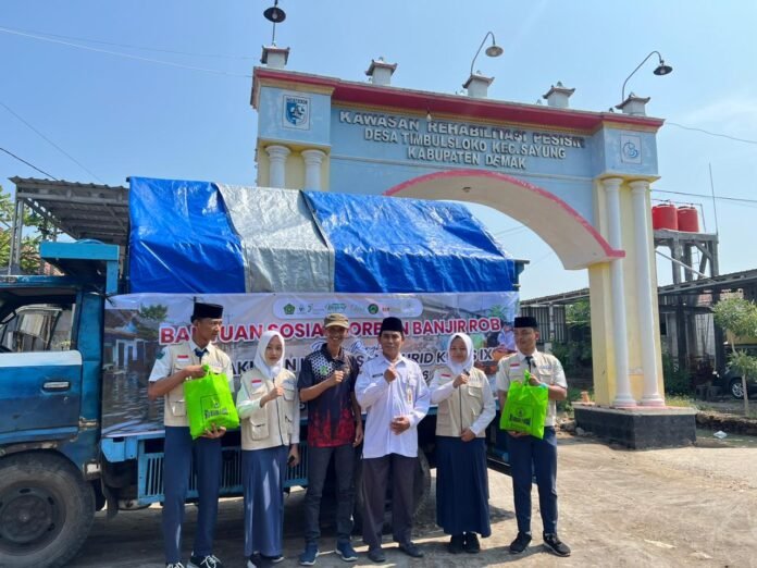 Siswa kelas IX MTsN 3 Demak tahun 2026 melakukan bakti sosial bagi warga terdampak banjir rob di Desa Timbulsloko, Kecamatan Sayung, Kabupaten Demak, Rabu (3/6/2026). (Foto : Sam)
