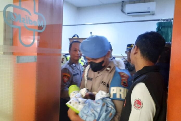 Anggota Polresta Surakarta menggendong bayi yang ditemukan di toilet kereta api. (Foto : Humas Polresta Surakarta)