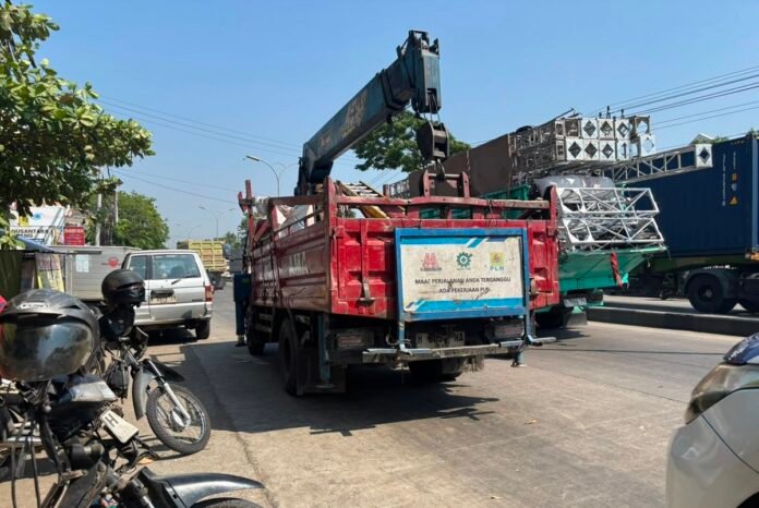 Sebuah truk yang diduga milik PLN dengan nomor polisi H 8057 NA tampak masih terparkir di tepi jalan tidak jauh dari lokasi kecelakaan.