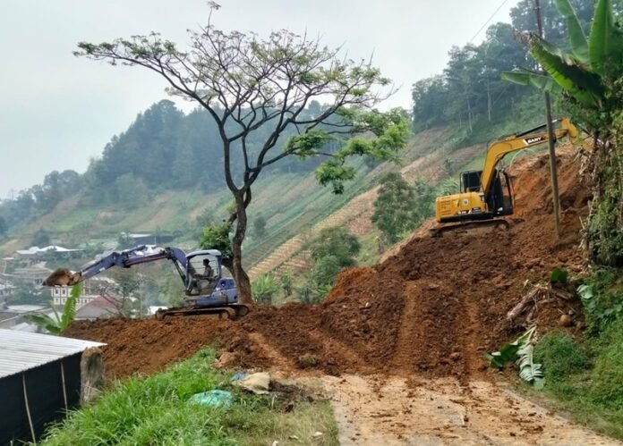 Sejumlah alat berat diturunkan untuk membuka akses jalan yang tertimbun longsor.