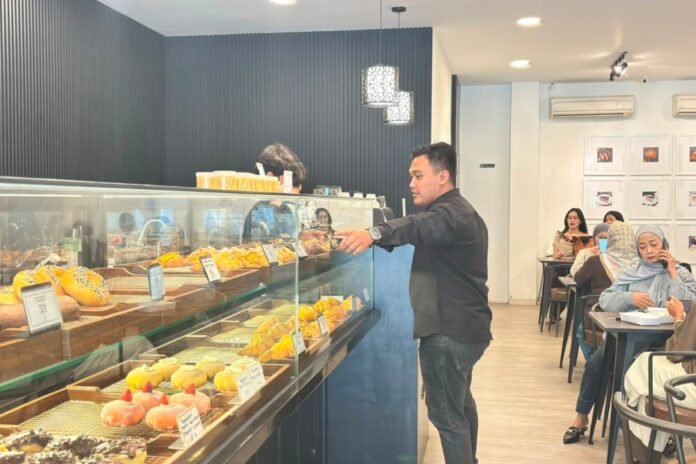 General Manager La Cerise Cafe Amirul Isnaini sedang mengecek persediaan pastry di etalase bakery, Minggu (2/8/2026). (Foto: Arif)