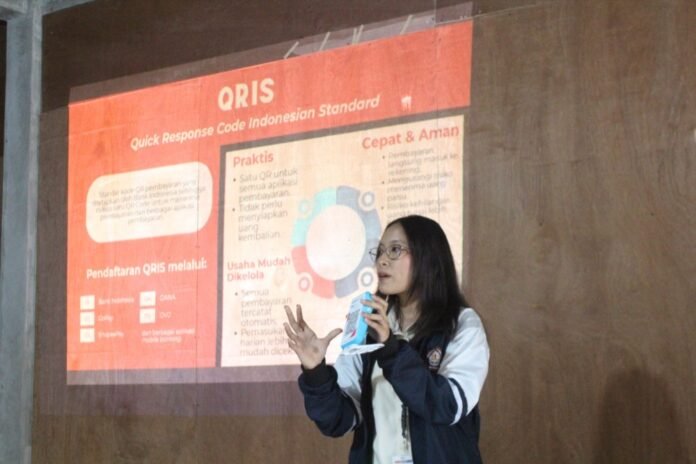Mahasiswa KKN-R Tim II Universitas Diponegoro (UNDIP) Desa Jerukan, Kecamatan Juwangi, Kabupaten Boyolali, menjelaskan proses pembuatan hingga penggunaan QRIS kepada pelaku UMKM. (Foto: Dok. KKN)