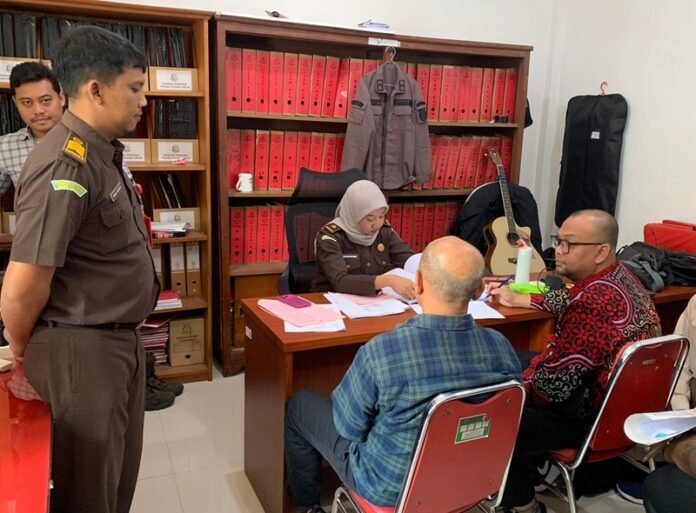 Tersangka dugaan penipuan dan penggelapan investasi GS ( baju hijau kotak, red) saat dilimpahkan ke Kejari Karanganyar.